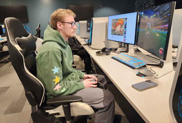 man with glasses at computer with two monitors playing esports