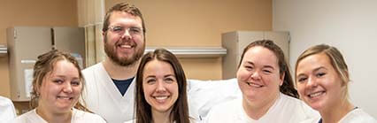 Group of people in white uniforms standing together in a clinical setting