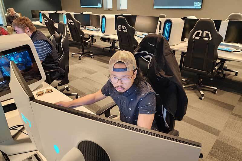 A male student looking intently at a computer screen