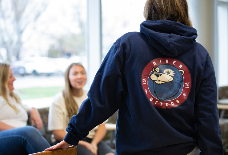 Students talking in the commons area wearing mascot apparel