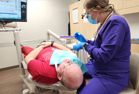 man in dental chair with hygienist ready to start the cleaning