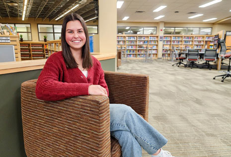 College girl sitting in chair in library