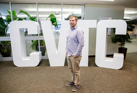 Man in college lobby in front of college letters