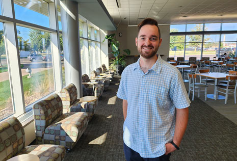 Technical college advisor stands in common area 