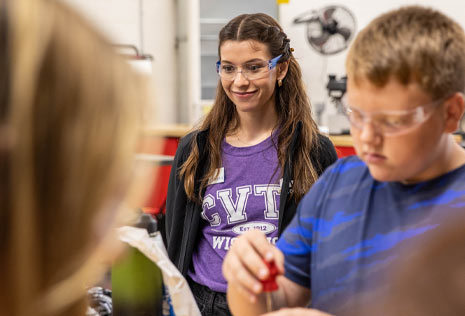 Woman at technical college helping middle school students tour the facility