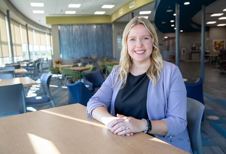 Woman sitting in a sun-soaked commons area