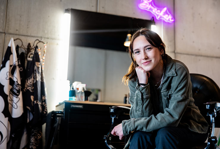 Brecken Anderson, 21, sits on a barber chair in a barbershop she opened in Eau Claire recently called Brecx Barbershop.